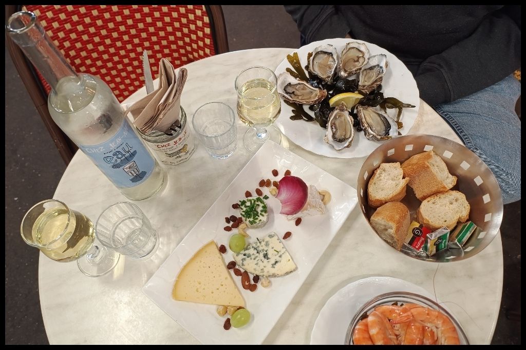 Table of fresh oysters, shrimp, an assortment of cheeses, and wine from the market 4-days in Bordeaux Itinerary